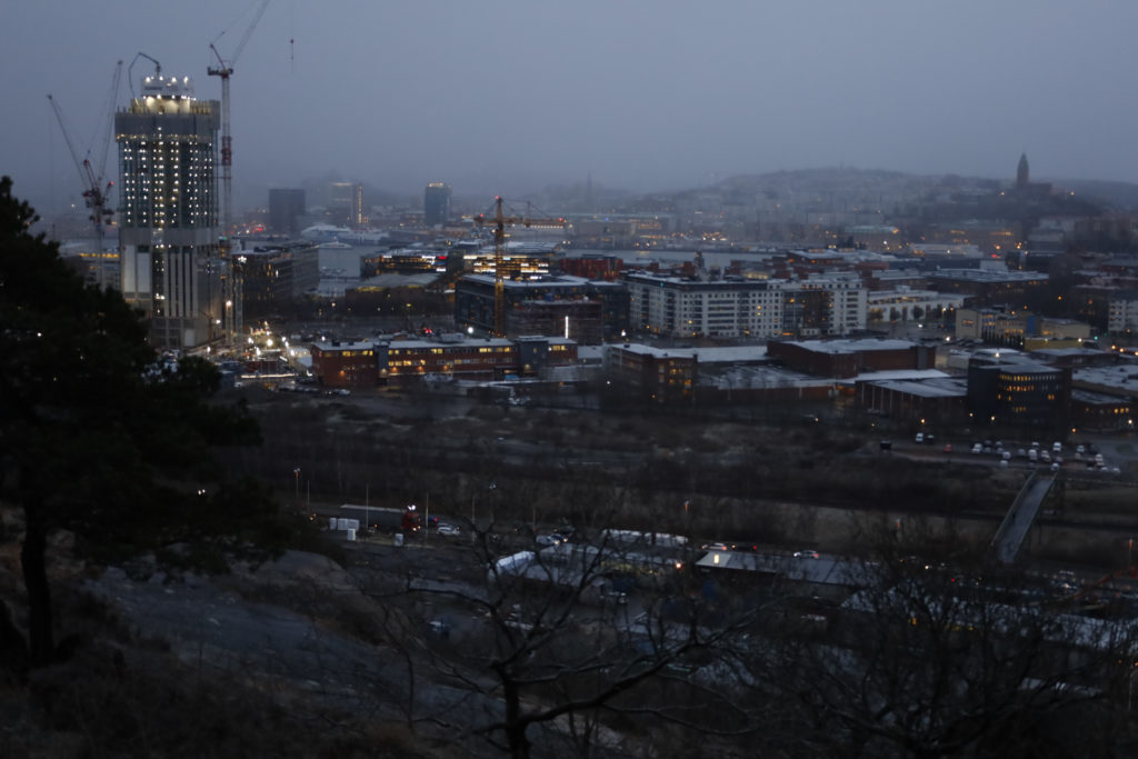 Utsikt från Ramberget i Göteborg. Nedanför berget en motorleden. Till vänster lyser byggnadskonstruktionen ifrån Karlatornet. I bakgrunden till höger syns Masthuggskyrkan.